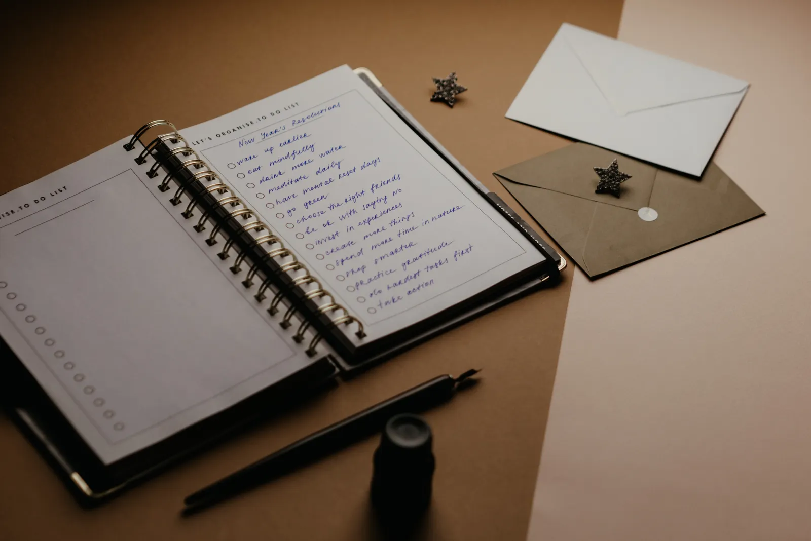 Notizbuch, Stift und Briefumschläge auf einem Schreibtisch