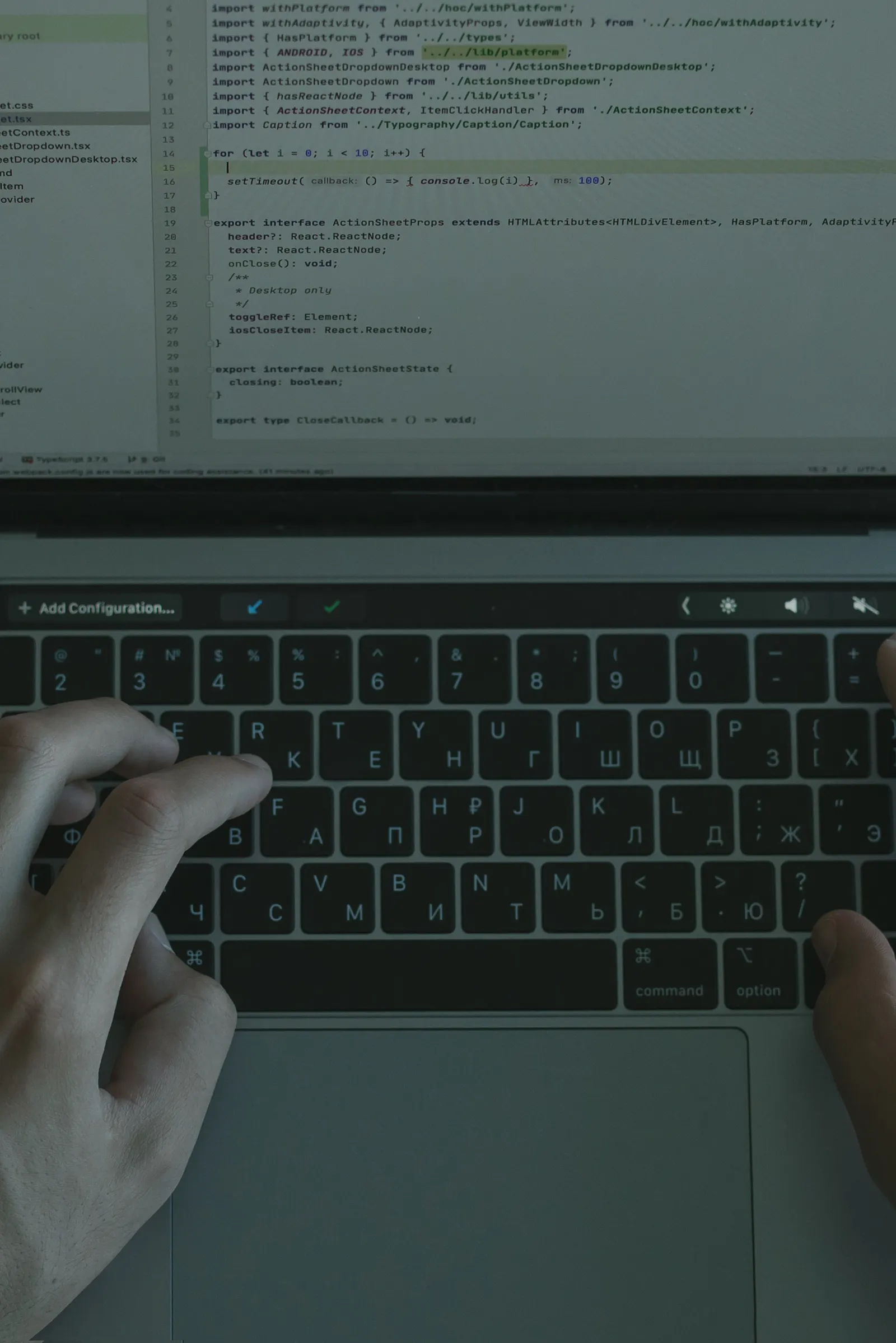Hände an einem Laptop mit geöffnetem Programmcode